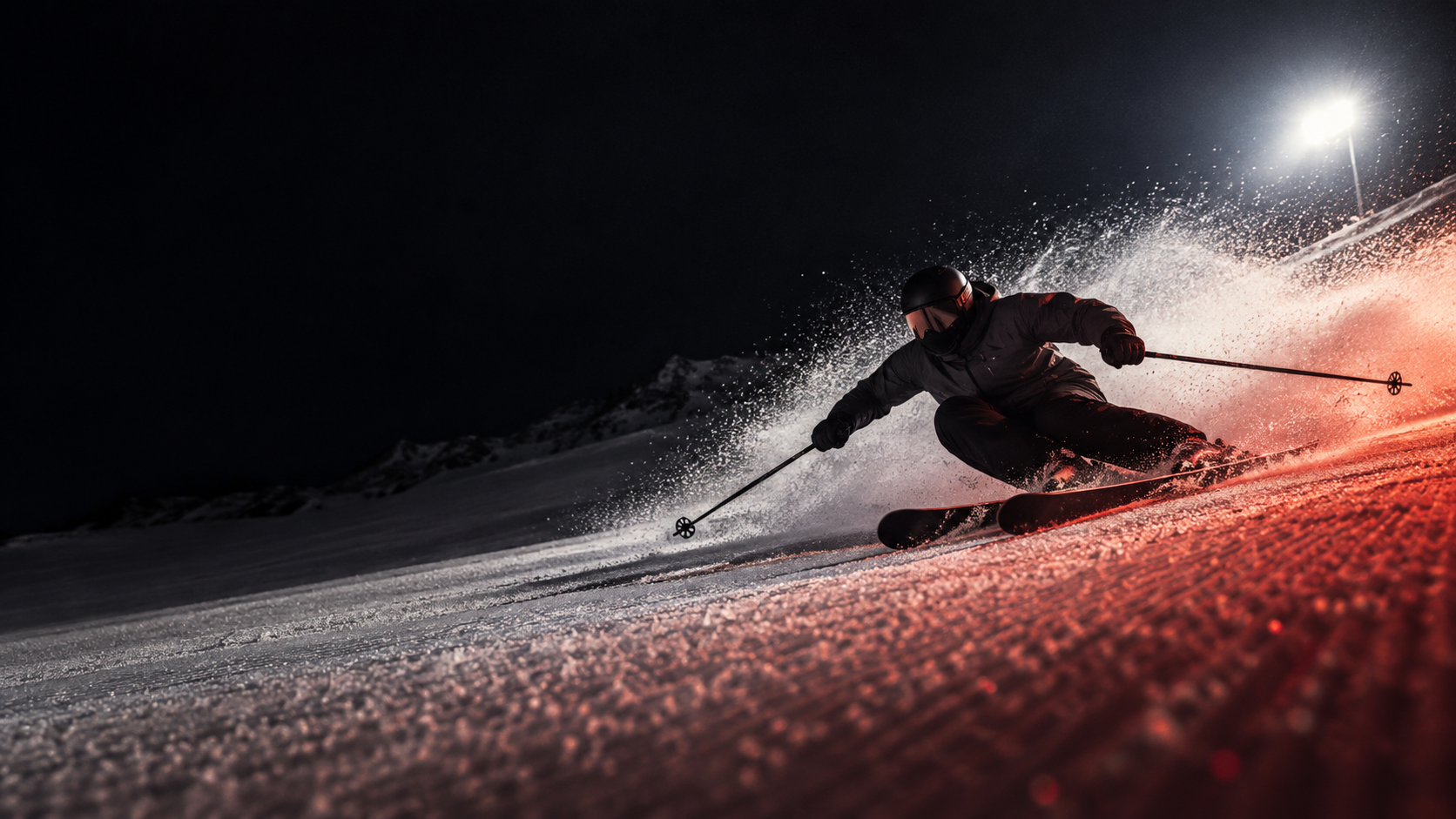 A skier carving under hard light through a cloud of orange-lit snow